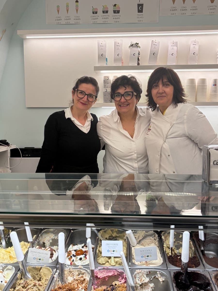 Three women behind the gelato counter at Pina Caruso's gelateria